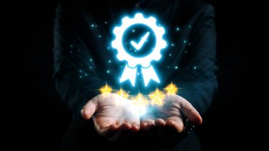 Parlayan yıldızlarla çevrili parlak bir sertifika ikonunun, siyah bir arkaplana karşı açık ellerde sergilenen resmedilmiş bir temsili. Dörtgen