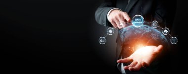 Bir işadamı, görsel ikonlar aracılığıyla gelişmiş yapay zeka teknolojisi ve küresel bağlantıları vurgulayarak, karanlık bir ortamda çevrimiçi iş sezgilerini harekete geçiren verileri sergiliyor. XDMCP