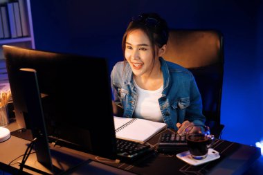 Gülümseyen genç, güzel Asyalı yaratıcı satış hedefi raporunun kar tablosuna bakıyor ve notlar üzerine notlar yazarak neon ışığı gecesinde yeni bir strateji pazarı projesine yatırım yapmayı planlıyor. Taktik.