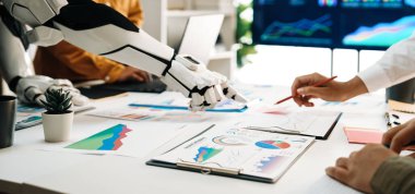 Veri görselleştirmeleri ve analitik çizelgelerle çevrili modern bir ofiste çalışan bir insan ve bir robotu gösteren bir sahne. Gelecekteki işbirliğini gösteriyor. Noogenesis