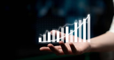 A person holds an animated growth chart in their hand, representing business success and performance in a modern digital setting with a focus on financial metrics. Impute