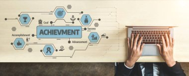 This image captures the concept of achievement in a business context, showcasing a laptop on a table surrounded by icons representing goals, success, and advancement. Tessel