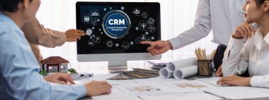 İç mimar tasarımcı grubu, daha kesin tasarım için planlar ve dizüstü bilgisayar ekran mimari yazılımı üzerinde birlikte tartışıyorlar. Modern ev tasarımı ve yenileme. İçgörü