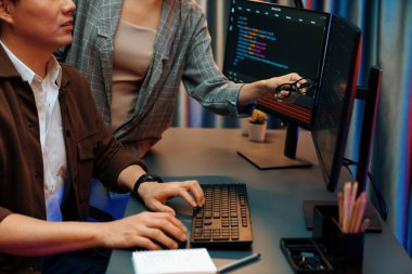 Bilgi teknolojisi geliştiricileri modern ofisteki neon ışık odasında verileri çevrimiçi olarak çalıştıran akıllı web sitesi geliştirme kodlayıcı sistemine işaret ediyorlar. İnfobahn.