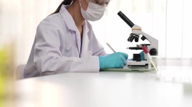 Laboratuvar kimya araştırmacısı mikroskop kullanarak yeni ilaç ya da tedavi geliştirir. Laboratuvar mikrobiyoloji ekipmanları ile bilimsel uzmanlık ile sağlık hizmetlerinin teknolojik gelişimi. Ağır çekim. Katı.