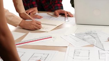 Mimarlık ve güvenlik mühendisi, modern ofiste dizüstü bilgisayarda mimari belge ve ahşap blokla sergilenen planlar hakkında tartıştı. - Yakın çekim. Tanımlama.