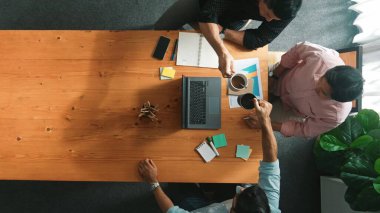 Akıllı iş adamlarının el çırparken dizüstü bilgisayara baktığı ve başarılı bir projeyi kutlamak ya da toplantıdaki satışları artırmak için beşlik çaktığı en tepeden aşağı hava görüntüsü. Cemaat.