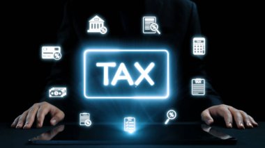 Bir işadamı, vergilendirme ve uyum karmaşıklığını gösteren çeşitli mali simgelerle çevrili dijital bir ekranda vergiyle ilgili bilgileri analiz eder. Dörtgen