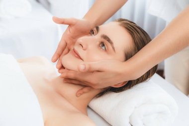 Kafkasyalı kadın stres önleyici kafa masajından ve lüks tatil beldesi ya da otel spa salonundaki modern ışık ortamında yüz güzelliği eğlencelerini şımartmaktan hoşlanıyor. Sessiz.