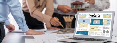 İç mimar tasarımcı grubu, daha kesin tasarım için planlar ve dizüstü bilgisayar ekran mimari yazılımı üzerinde birlikte tartışıyorlar. Modern ev tasarımı ve yenileme. İçgörü