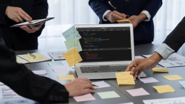 Analizci ekibi yaratıcı ve analitik beyin fırtınası fikri için bilgisayar ekranında BI veri paneli olan yapışkan bir not kullanıyor. Pazarlama stratejisi için finansal veri görselleştirme teknolojisini analiz et. Dahi.