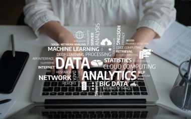 A focused view of hands typing on a laptop covered with cloud computing and data analytics terms, symbolizing the essence of modern business technology and insights. Tessel