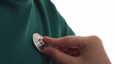 Hasta klinikte ya da hastane ofisinde doktor randevusuna gidiyor. Hastaların risk faktörünü tespit etmek için nabzını ölçmek için steteskopla doktor muayenesi ve teşhis semptomları. Ağır çekim. Katı.