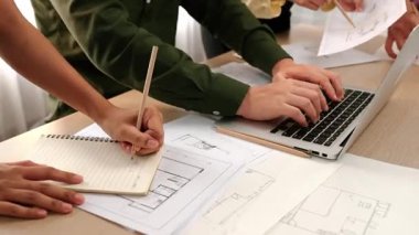 Modern ofiste doğruluk için mimari belge ya da plan ve ölçüm aracıyla birlikte dizüstü bilgisayarda mimari ayrıntılı planlama ve ölçüm projesine danışmanlık yapan mimar ve mühendis. - Yakın çekim. Tanımlama.