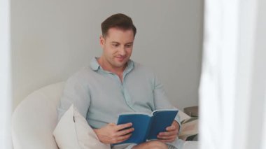 Kanepede oturan orta yaşlı bir adam, sosyal ve teknolojik mesleki gelişmeler hakkında ders kitabı okur ya da çocukları iyi bir yetişkin baba olmak için yetiştirir. Hayat boyu öğrenme konsepti. Uyumsuzluk.