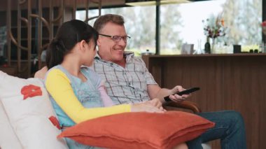 Büyükbaba ve torun birlikte TV 'de ilginç bir eğlence medyası izliyorlar. Eski üst düzey kullanım teknolojisi, genç nesil çapraz nesil ile iletişim kurarak aile bağlarını güçlendiriyor. Uyumsuzluk.