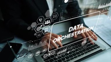 Professional Hands Typing on Laptop with Data Orchestration Icons and Graphics Displayed in a Modern Workspace Environment. Asymptotic smart data analytic.