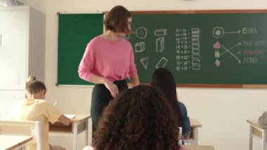 Zeki öğretmen sınıfta fikri açıklarken sevimli öğrenci ödevlerini kontrol ediyor. Not defterine bakıp matematik teorisinden çocuğa bahsederken sınıfta dolaşan çekici bir eğitmen. Pedagoji.