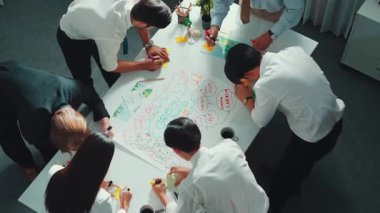 Profesyonel iş adamlarının zihin haritasını kullanarak beyin fırtınası yapmak için birlikte çalıştıklarına dair üst düzey bir görüş. Akıllı yöneticilerin sürdürülebilir enerji hakkında konuştuğu ve tartıştığı hava görüntüsü. Hizalama.