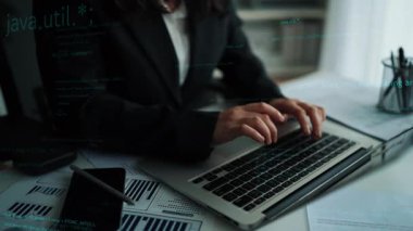 A focused individual types on a laptop in a modern workspace, surrounded by floating code and digital symbols, showcasing technology and digital innovation in action. Xenic
