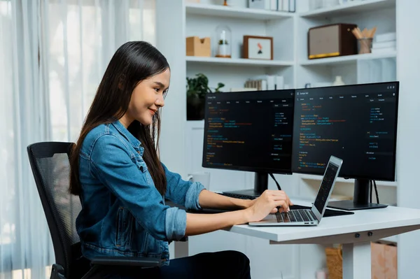 IT geliştiricisinde gülümseyen genç Asyalı dizüstü bilgisayarında kodlama programı verileriyle kotlu tişört giyerek çevrimiçi bilgi yazıyor. Güvenlik analizi iki ekran ile çevrili. Taktik.