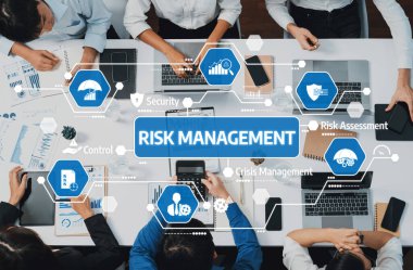 A top-down view of professionals engaged in risk management discussions, utilizing modern technology and collaboration to enhance corporate strategies. Amity