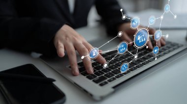A close-up view of hands typing on a laptop keyboard is enhanced with digital network icons, symbolizing technology, innovation, and connectivity in a modern workspace. Tessel