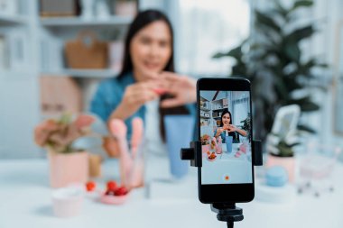 Kozmetik makyaj makyajı, ruj, pastel renkler, sosyal medyada kol testi promosyonunda en çok satan kitaplar koleksiyonunu gösteren seçici odaklı telefon. Taktik.