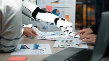 Profesyonel ve zeki asistanların iş raporlarını ve optimal sonuçlar için rafine stratejileri analiz ettikleri modern bir ofiste yapay zeka destekli işbirliği. Noogenesis Yapay Zeka