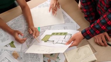 Mimari döküman, ölçüm araçları ve ahşap blokların modern ofiste etrafa saçıldığı masa üzerine planlar yapma konusunda akıllı mimar ve güvenlik mühendisi tartışması. - Yakın çekim. Tanımlama.