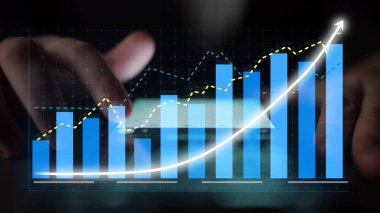 A close-up view of hands engaging with a touchscreen displaying dynamic charts and graphs, representing financial growth and detailed analytics for modern businesses. Copula