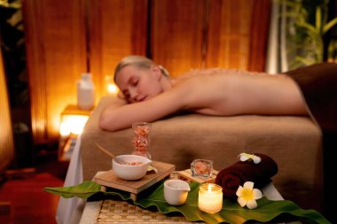 Lüks spa salonlarında sıcak mum ışığında cilt bakımı yaptıran kadın müşteri. Sağlık Spa vücut fırçasında tuz temizleme güzellik tedavisi. Sessiz.