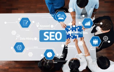 A dynamic scene showing professionals working together on an SEO strategy. The image features icons for data mining, keywords, best practices, and planning, symbolizing collaboration. Amity