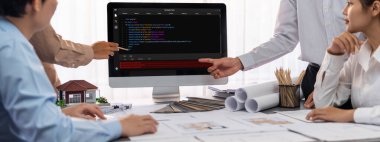 İç mimar tasarımcı grubu, daha kesin tasarım için planlar ve dizüstü bilgisayar ekran mimari yazılımı üzerinde birlikte tartışıyorlar. Modern ev tasarımı ve yenileme. İçgörü