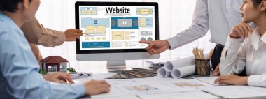 İç mimar tasarımcı grubu, daha kesin tasarım için planlar ve dizüstü bilgisayar ekran mimari yazılımı üzerinde birlikte tartışıyorlar. Modern ev tasarımı ve yenileme. İçgörü