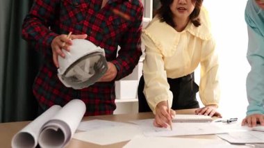 Mimari döküman, ölçüm araçları ve ahşap blokların modern ofiste etrafa saçıldığı masa üzerine planlar yapma konusunda akıllı mimar ve güvenlik mühendisi tartışması. - Yakın çekim. Tanımlama.