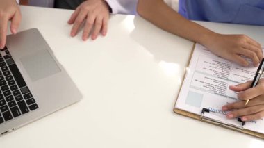 Hastane masasında birlikte çalışan ve tıbbi tedavi planlayan çeşitli profesyonel sağlık görevlileri. Takım çalışması başarılı hastalıklara ve hastalıklara yol açar. Ağır çekim. Katı.