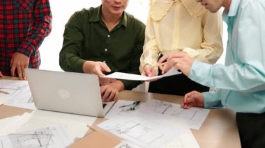 Mimar ve güvenlik mühendisi, masadaki dizüstü bilgisayardaki inşaat detaylarını mimari belge ve modern ofiste doğruluk için ölçüm aracıyla karşılaştırıyor. - Yakın çekim. Tanımlama.