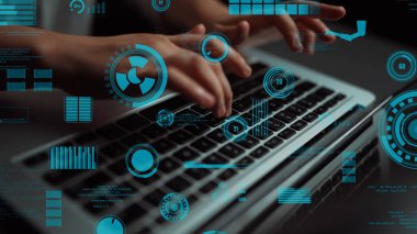 A close-up view of hands typing on a laptop, enhanced by futuristic graphical overlays and data visualizations, representing modern technology and digital innovation. Xenic