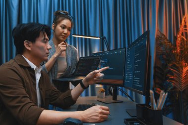 Modern ofisteki neon ışık odasında bilgi ağını gösteren dizüstü bilgisayarla iki ekranda veri çalıştıran akıllı web sitesi geliştirme kodlayıcı sistemini tartışan IT geliştiricilerinin ciddiyeti. İnfobahn.