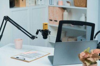 Beyaz masada duran tüm canlı yayın setleri dizüstü bilgisayar, mikrofon, kulaklık, ağaç, senaryo notu ve kalemden oluşur. Sosyal medyada canlı yayında sunucu kanalı için beklemedeyiz. Taktik.