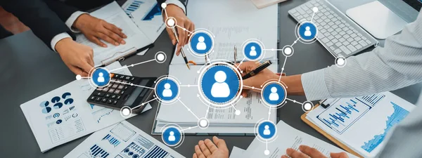 A dynamic office scene showcases a team engaged in networking and collaboration, discussing strategies and analyzing data to drive project success and enhance productivity. Amity