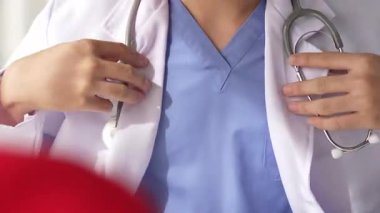 Hasta klinikte ya da hastane ofisinde doktor randevusuna gidiyor. Hastaların nabzını steteskopla kontrol edip risk faktörünü belirleyen doktor semptomları inceliyor. Panorama. Katı.