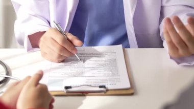 Hastanedeki doktor masasında oturup hasta test sonuçlarını teşhis eden, hastalıklar ve hastalıklar için tedavi planı geliştiren evrak işleriyle uğraşıyor. Sağlık personeli ve sağlık hizmetleri. Ağır çekim. Katı.