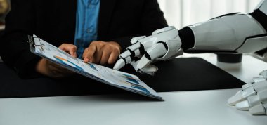 Bir insan ve robotu modern çalışma alanlarında insan zekasının ve robot yardımının füzyonunu vurgulayan bir iş tartışmasında gösteren ilgi çekici bir görüntü. Noogenesis