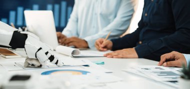 Bu resim modern ofis ortamında profesyonellerle işbirliği yapan, teknoloji ve insan etkileşiminin iş süreçlerinde entegrasyonunu vurgulayan bir robotu tasvir ediyor.