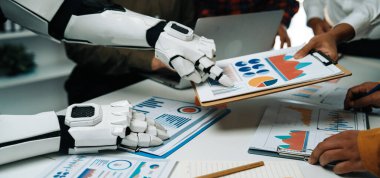 Bir robot kol, bir grup profesyonele veri analizinde, teknoloji ve insan işbirliğinin dinamik ofis ortamında entegrasyonunu göstermede yardımcı olur. Noogenesis