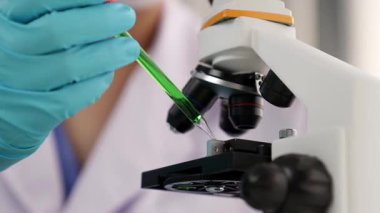 Laboratuvar kimya araştırmacısı mikroskop kullanarak yeni ilaç ya da tedavi geliştirir. Laboratuvar mikrobiyoloji ekipmanları ile bilimsel uzmanlık ile sağlık hizmetlerinin teknolojik gelişimi. Ağır çekim. Katı.