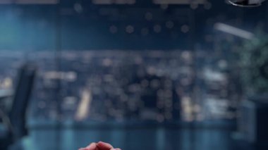 Bir insan eli ve robotik el, modern bir çalışma alanındaki teknoloji ve insan etkileşiminin karışımını gösteren dijital bir finans grafiği üzerinden bağlanmaya hazırdır. Auvana