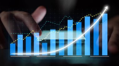A close-up view of hands interacting with a digital screen displaying various financial graphs and charts, showcasing significant business growth and analysis trends. Copula